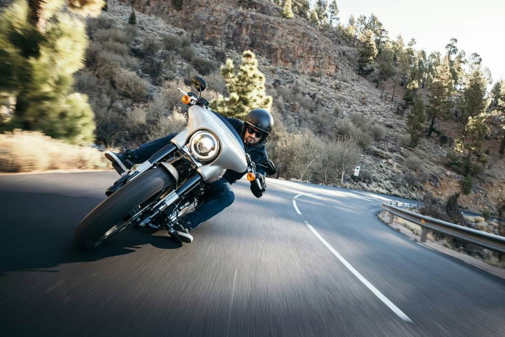 O que a garantia de moto cobre? Comprar uma moto é um investimento importante e entender o que a garantia cobre é um bom ponto de partida para evitar surpresas desagradáveis no futuro. A garantia do fabricante é um compromisso de que o veículo está livre de defeitos de fabricação, mas ela tem limites. Imagem de um homem pilotando moto em uma curva na estrada
