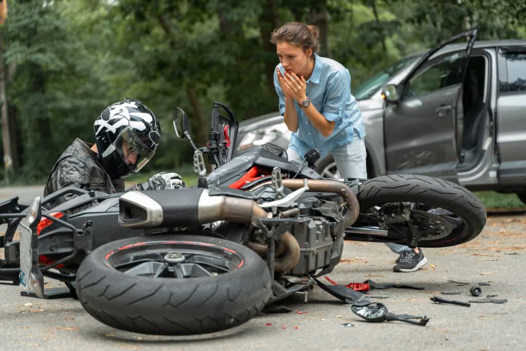 O que a garantia de moto cobre? Comprar uma moto é um investimento importante e entender o que a garantia cobre é um bom ponto de partida para evitar surpresas desagradáveis no futuro. A garantia do fabricante é um compromisso de que o veículo está livre de defeitos de fabricação, mas ela tem limites. Imagem mostra colisão entre motocicleta e carro na estrada, situação que a garantia de moto não cobre