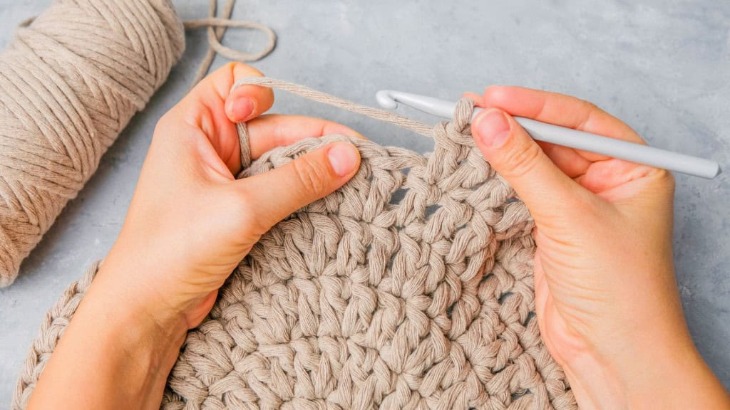 5 hobbies de vovó para você manter o cérebro ‘jovem’ por mais tempo Manter o cérebro jovem pode ser mais simples e prazeroso do que parece. Um estudo recente revelou que hobbies tradicionalmente associados às “vovós”, como tricô, jardinagem, costura e crochê, podem prolongar a vida em até oito anos. Closeup de mãos segurando gancho de crochê e fio de cordão fazendo um tapete com pontos de crochê duplo