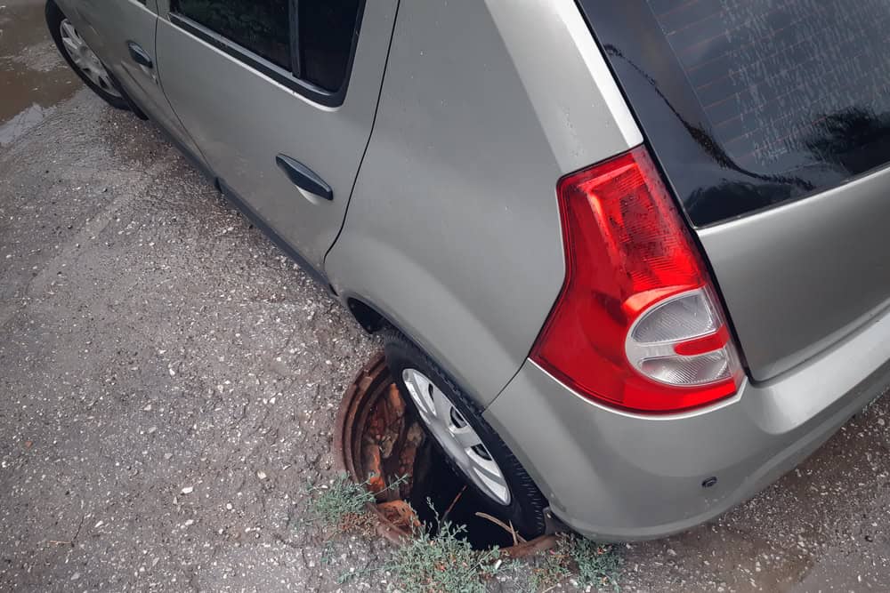 Estacionar sobre uma tampa de bueiro dá multa? Veja o que diz a lei Ao estacionar o seu carro em uma rua, pode acontecer de você deixar a roda do veículo em cima de uma tampa de bueiro. Apesar de parecer uma ação normal, isso é capaz de gerar prejuízos para o seu automóvel e ainda dar dores de cabeça com as autoridades de trânsito. Carro afundou em bueiro