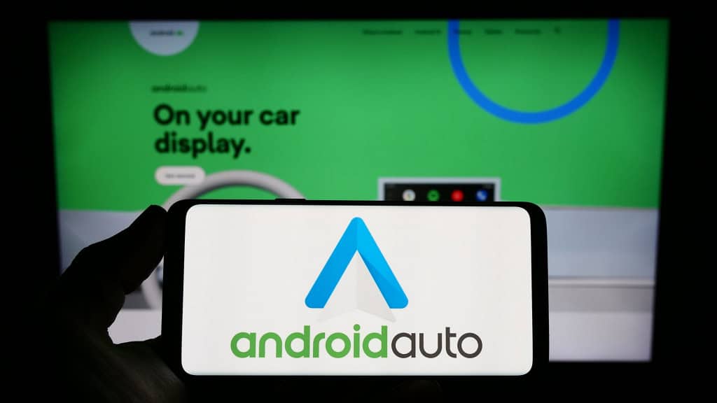 6 configurações do Android Auto que você deveria alterar O Android Auto é uma ferramenta poderosa que transforma a tela do seu carro em uma extensão do seu smartphone, permitindo acesso a apps como Google Maps, Spotify, WhatsApp e muito mais. Estugarda, Alemanha - 14-03-2023: Pessoa segurando smartphone com o logotipo do aplicativo móvel Android Auto (Google) na tela em frente ao site. Foco na tela do telefone. Foto não modificada
