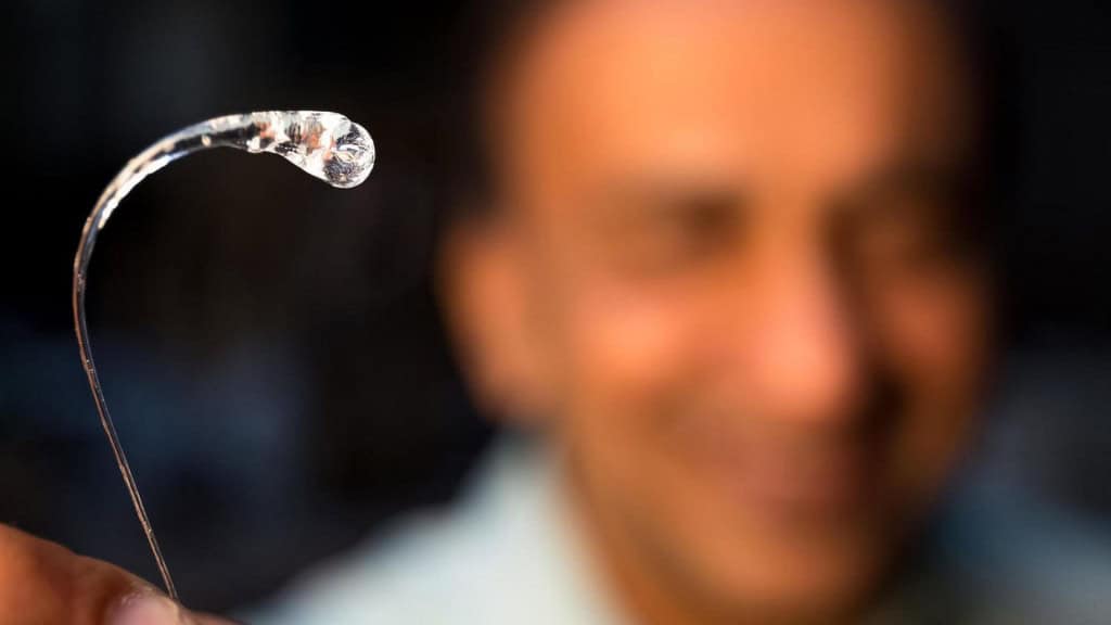 Homem segurando gota de vidro, também chamada de Gota do Príncipe Rupert