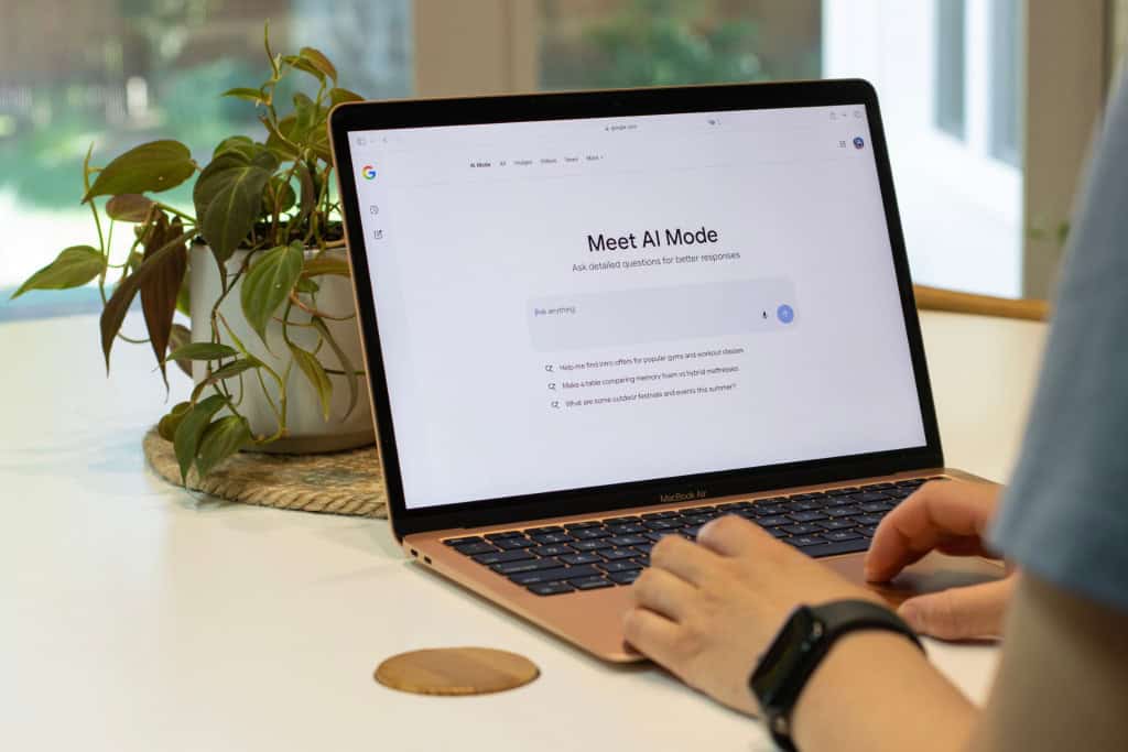 Pessoa mexe em notebook com a tela na página do Google AI Mode