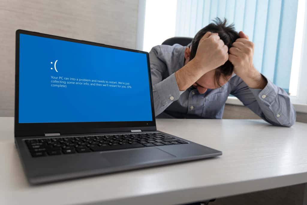 5 perigos de baixar softwares crackeados no seu computador A decisão de instalar um software crackeado no seu PC pode parecer tentadora para economizar alguns reais, mas é bom ficar sabendo que esse único programa pirata é suficiente para colocar toda a sua segurança digital em risco. Imagem mostrando tela azul de erro no laptop contra o fundo de um homem chateado e irritado segurando a cabeça