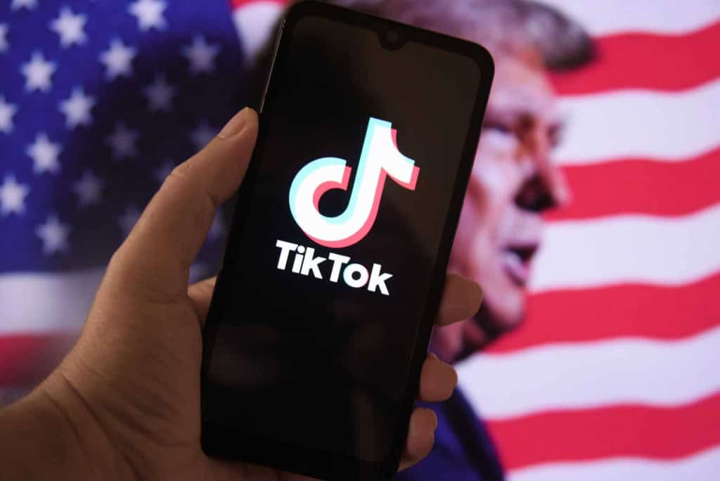 ByteDance deve ter papel central na nova estrutura do TikTok nos EUA A ByteDance terá uma participação maior do que o esperado na nova entidade do TikTok que será vendida a investidores estadunidenses e globais, em um esforço para atender às preocupações de segurança nacional dos Estados Unidos. A informação foi revelada por três fontes com conhecimento direto do assunto à agência Reuters. Ao fundo, bandeira dos EUA e imagem de Donald Trump; à frente, logo do TikTok em um smartphone