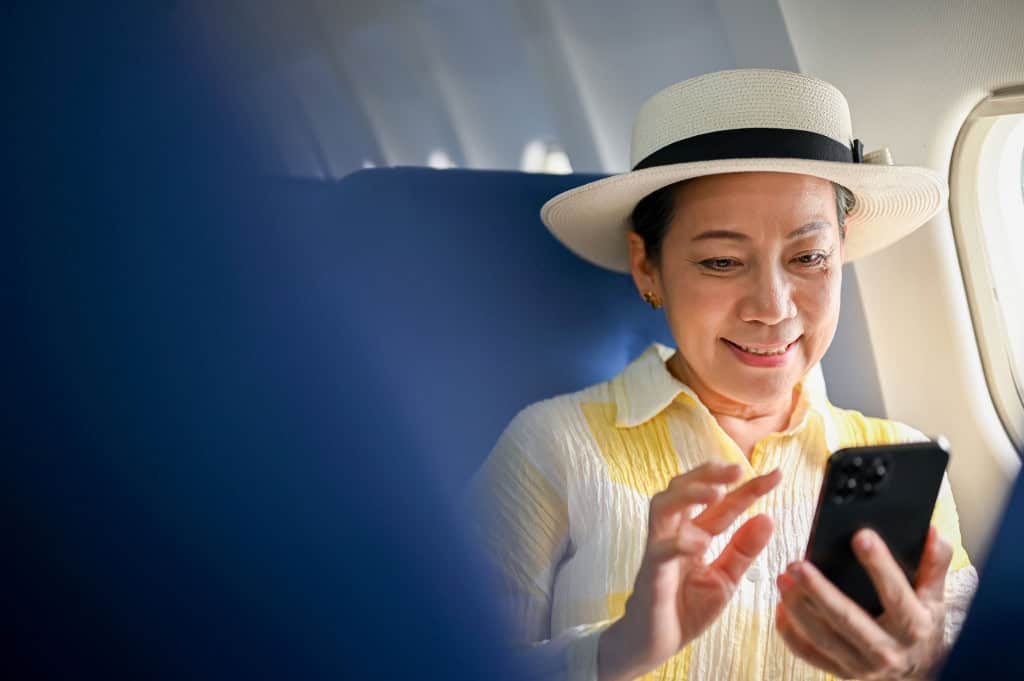 O que é o modo avião no celular? Aprenda para que serve, como usar e dicas Você provavelmente já ativou o modo avião do celular em algum momento, seja antes de um voo ou até para economizar bateria. Mas será que conhece todas as vantagens desse recurso? Turista mexendo no celular em e=avião