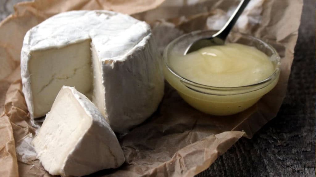 Roda de queijo com uma fatia sobre papel