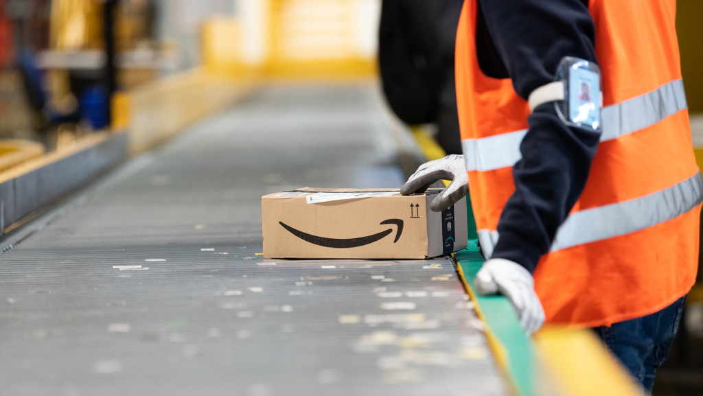 Modo ‘startup gigante’: Amazon vai cortar 14 mil cargos e apostar em IA A Amazon anunciou, nesta terça-feira (28), a redução de cerca de 14 mil cargos corporativos numa nova rodada de demissões. O objetivo é reduzir burocracia e realocar recursos, com foco em iniciativas de inteligência artificial (IA), diz a empresa. trabalhador amazon