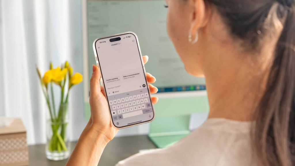 Mulher usando ChatGPT num iPhone