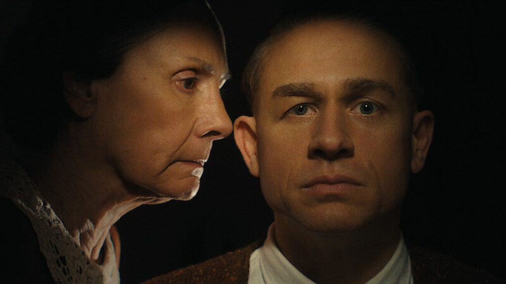 “Monstro: A História de Ed Gein”: o que é verdade e mentira na série da Netflix A terceira temporada da série “Monster”, da Netflix, é focada no serial killer Ed Gein. Também conhecido como o “Açougueiro de Plainfield”, Gein foi preso em 1957 após autoridades encontrarem em sua casa objetos macabros feitos com restos humanos. mulher de meia idade falando algo no ouvido de um homem