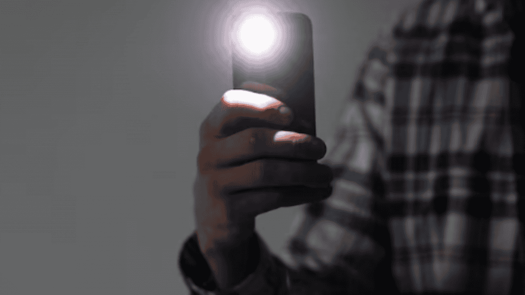 pessoa segurando iphone com flash