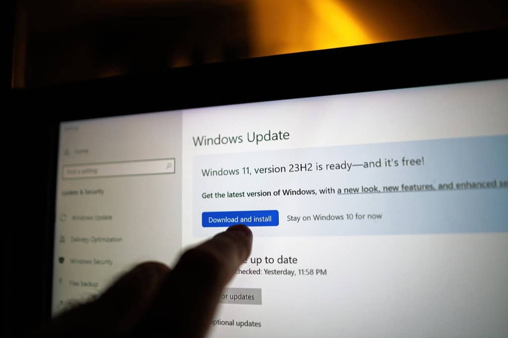 Monitor mostrando que há uma atualização disponível para o Windows 11 enquanto uma pessoa aponta para esta informação