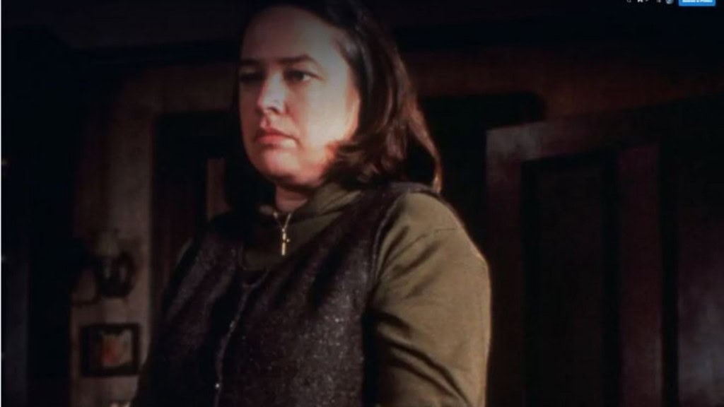 Mulher de cabelos curtos pretos olhando para algo seriamente 