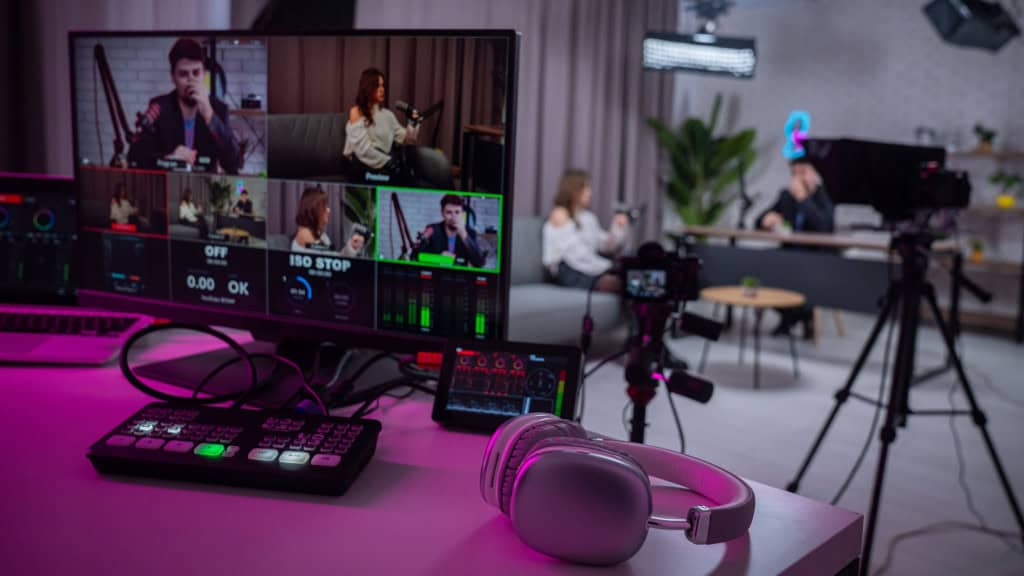 A nova guerra da Netflix: roubar público do YouTube com videocasts A Netflix quer colocar podcasts em vídeo dentro do próprio catálogo, abraçando de vez um formato que antes evitava. A ideia é disputar a atenção de quem assiste conteúdo casual no YouTube e no TikTok, onde a audiência jovem gasta horas em conversas, análises e entrevistas em ritmo de “programa de TV de bolso”. Pessoas gravando podcast em áudio e vídeo em estúdio