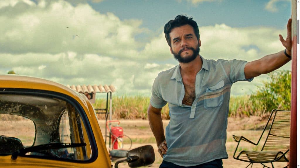 Wagner Moura vence prêmio de Melhor Ator em evento em Nova York O ator Wagner Moura conquistou nesta terça-feira (2) o prêmio de Melhor Ator do New York Film Critics Circle (NYFCC) por sua performance como Marcelo/Armando em O Agente Secreto. Wagner Moura encostado em uma parede ao lado de um carro