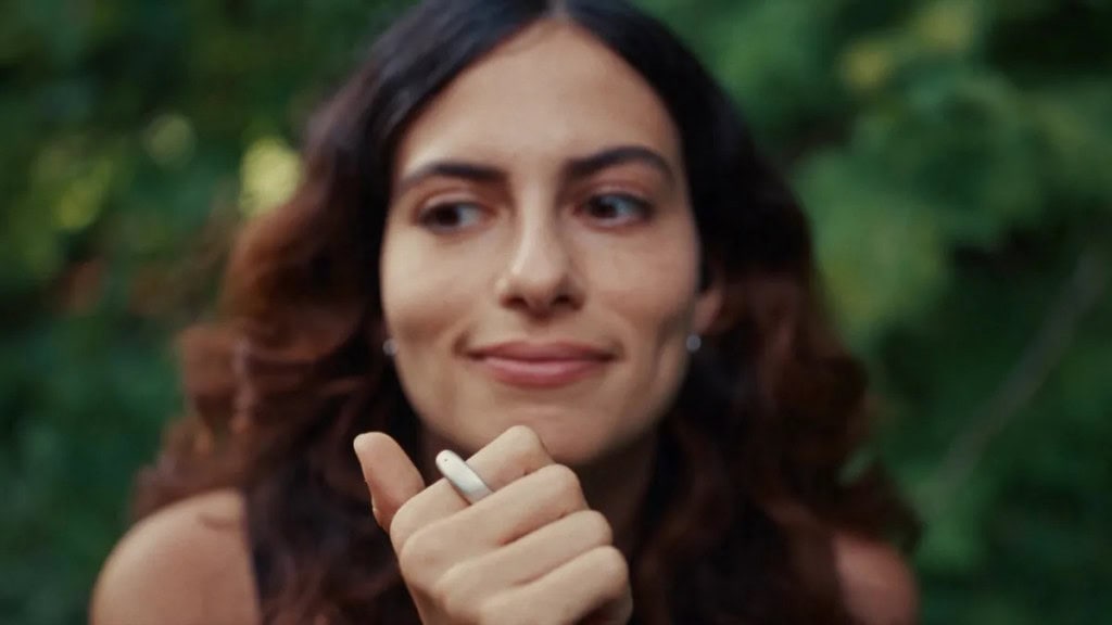 Fale, grave e organize: anel Stream leva o assistente de IA para as pontas dos dedos Dois ex-funcionários da Meta decidiram reinventar a maneira como interagimos com a tecnologia. Eles criaram o Stream, um anel inteligente que grava notas de voz, conversa com um assistente de IA e ainda permite controlar músicas – tudo com um simples toque no dedo. Mulher usando o anel inteligente Stream no dedo indicador.