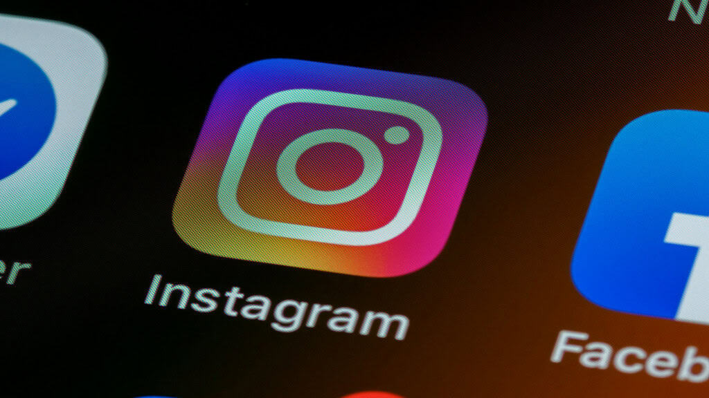 CEO do Instagram comenta um dilema moderno: como identificar conteúdo feito por IA? É fato: conteúdos produzidos por inteligências artificiais estão tomando conta de toda a internet, e é cada vez mais difícil identificar o que é real ou não. O problema tende a crescer nos próximos anos, o que levanta um debate relacionado a como podemos fazer para diferenciar o conteúdo orgânico criado por seres humanos das imagens e vídeos criados por IA. Ícone do instagram em um smartphone