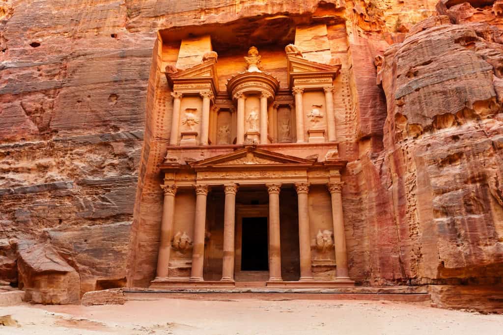 Conheça Petra, a cidade perdida esculpida em rochas Talvez você já tenha ouvido falar de Petra, uma das várias cidades perdidas e lendárias do mundo. Localizada na região do deserto da Jordânia, a 1,5 mil metros de altitude, ela é singular, pois suas edificações foram talhadas na rocha avermelhada. Edificação de Petra