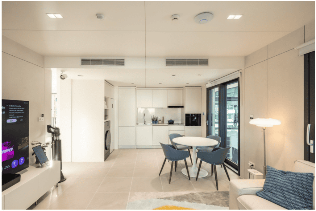 IA por todos os lados: conheça as casas modulares da Samsung Uma casa com inteligência artificial perfeitamente conectada. É assim que a Samsung está reimaginando os espaços residenciais em construções modulares, um projeto que pode chegar ao mercado global já no ano que vem. Esse tipo de construção é feita a partir de “blocos” pré-fabricados que, depois, são transportados e montados no local, como se fossem peças de um quebra-cabeça. sala modular