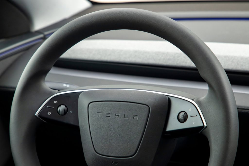 Tesla: Elon Musk prevê aprovação total da direção autônoma na China em 2026 O CEO da Tesla, Elon Musk, afirmou que espera a aprovação completa do software de direção autônoma da montadora, conhecido como Full Self-Driving (FSD), na China até o início de 2026. O anúncio foi feito durante a assembleia anual da empresa, quando o executivo revelou que o sistema já possui aprovação parcial no país desde fevereiro deste ano. As informações são da Reuters. Volante de um Tesla