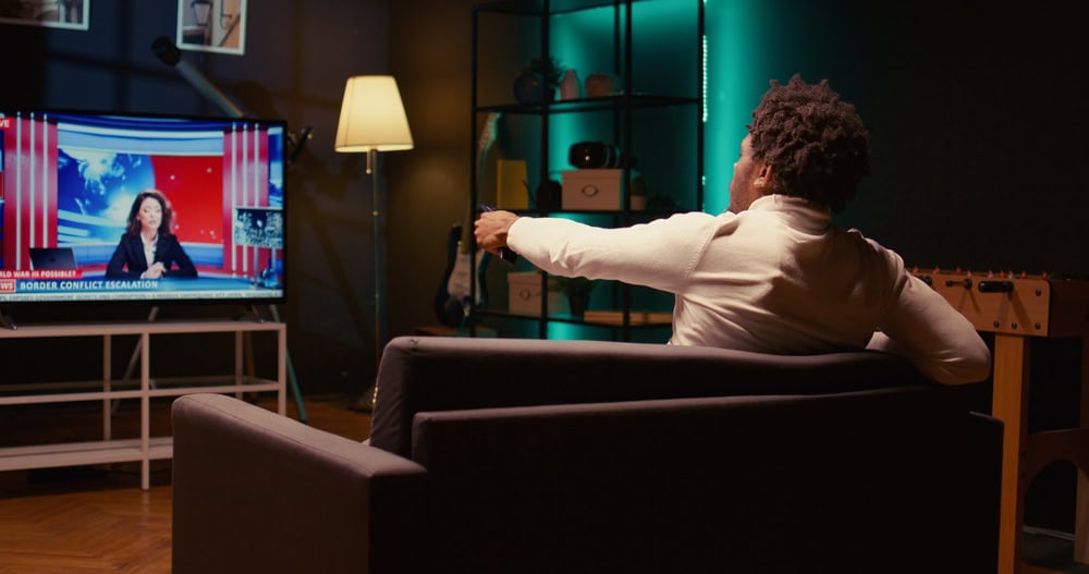 Pessoa trocando canal de TV