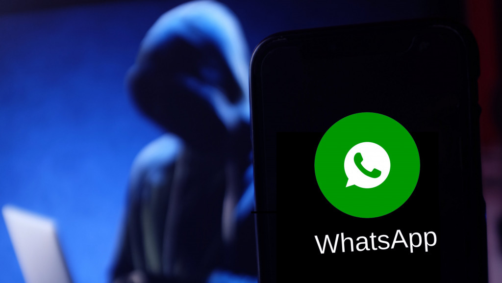 Cuidado! Vírus bancário transforma seu WhatsApp em arma contra amigos Pesquisadores da empresa de cibersegurança Acronis identificaram uma nova ofensiva do malware bancário Astaroth que afeta o Brasil. Batizada de “Boto Cor-de-Rosa“, a campanha passou a usar o WhatsApp Web como canal de infecção, explorando a confiança entre contatos. Celular com ícone do WhatsApp na tela; ao fundo, um hacker encapuzado usando um notebook
